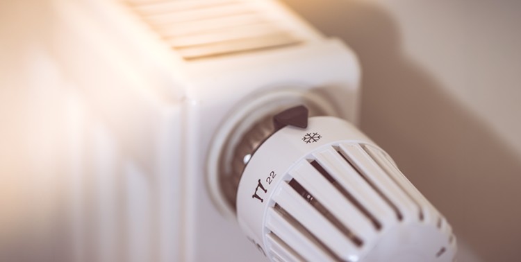Nahaufnahme eines weißen Heizkörpers mit Thermostat.