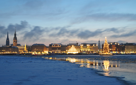 Vater und Sohn sitzen vor einem Bildschirm, während der Vater dem Kind lächelnd über die Schulter schaut. Seine Hand liegt auf der linken Schulter des Jungen. Links im Bild ist das Logo der Erich Thor Wohnungsunternehmen GmbH mit weißer Schrift auf blauem Hintergrund zu sehen.
